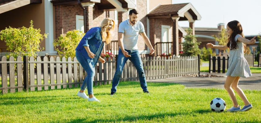 Family playing soccer in the yard